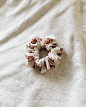 Load image into Gallery viewer, “Tossed Footballs on Ivory” Scrunchie

